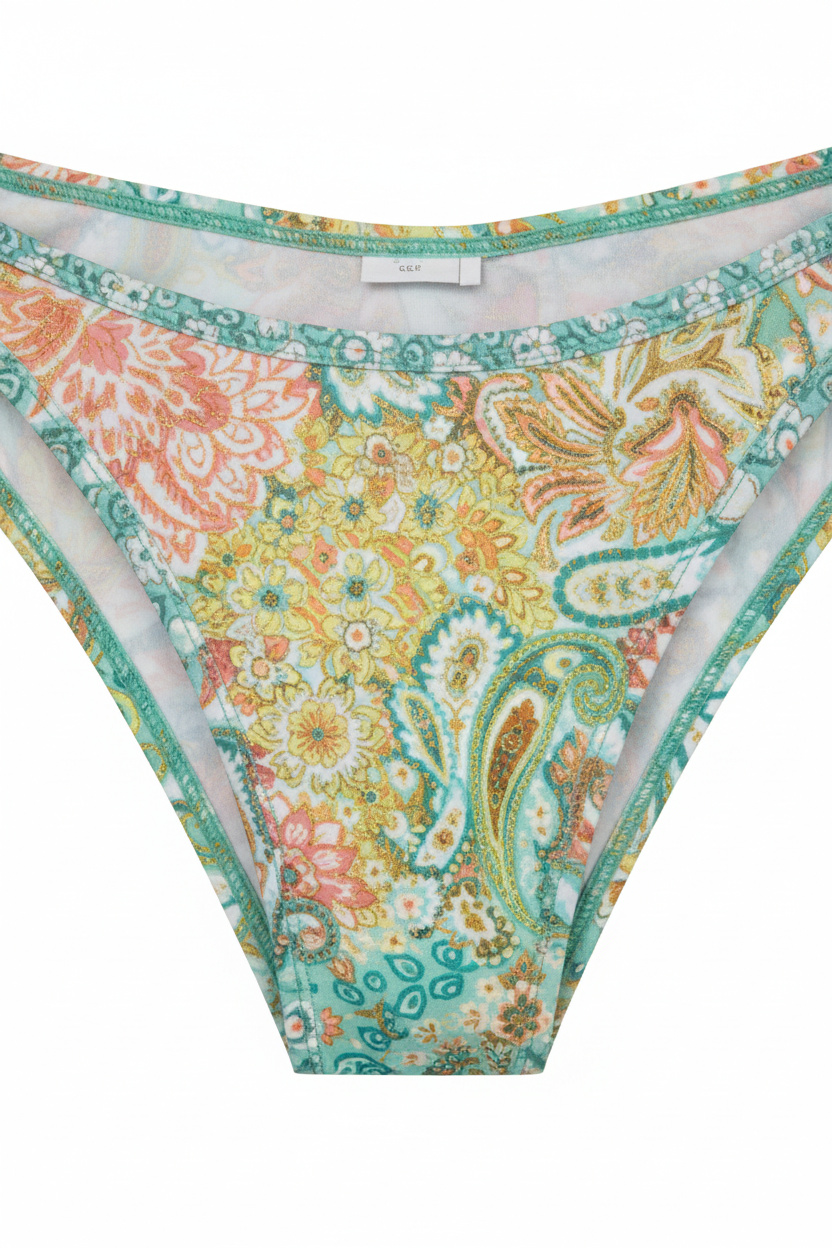Close-up detail of cheeky bikini bottoms in mint green and gold paisley print showing fabric texture